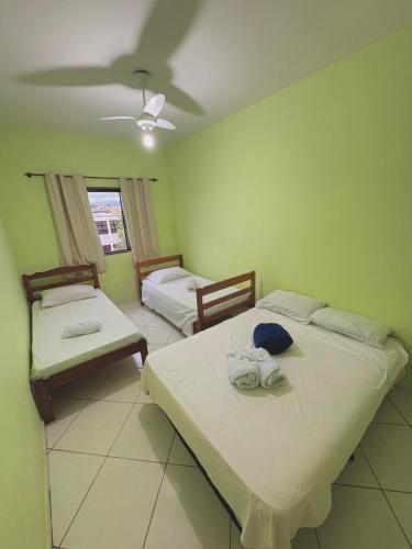 a room with two beds and a ceiling at Pousada Costa Rio - Conforto e Hospitalidade em Rio das ostras in Rio das Ostras