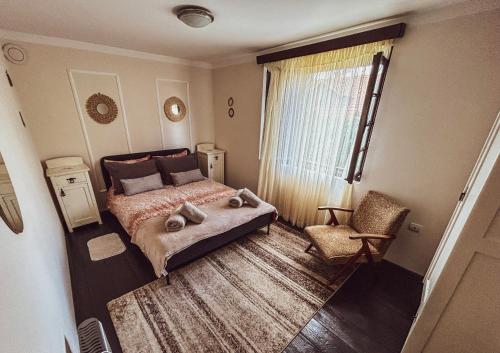a bedroom with a bed and a chair and a window at Kuća za odmor Banja Koviljača in Banja Koviljača