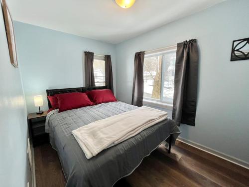 a bedroom with a bed with red pillows and a window at Private Room-Shared Common Spaces-Queen Bed in Johnson City