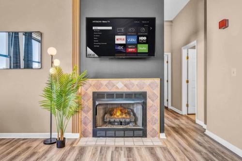 a living room with a fireplace with a tv above it at Funky 2B Apt in Downtown Cleveland FREE Parking in Cleveland