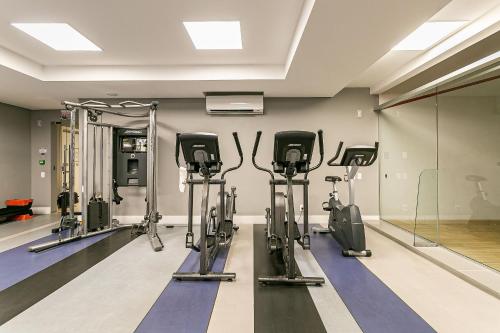 a gym with several tread machines in a room at WI-FI 200MB | Rooftop | Pool with Sea View #CA70D in Florianópolis
