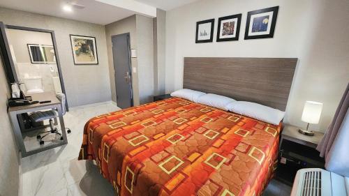 a bedroom with a bed and a desk in it at Hotel Fuego Bronx near Yankee Stadium in Bronx