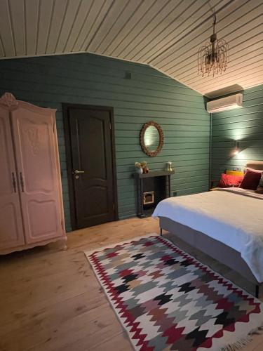 a bedroom with a bed and a rug and a mirror at Хлеча house in Stantsiya Korchi