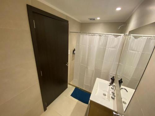 a bathroom with a sink and a shower with a mirror at Oceano in Necochea