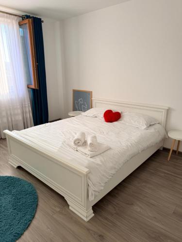 a bedroom with a white bed with two dolls on it at Jazz Residence 2 in Piatra Neamţ
