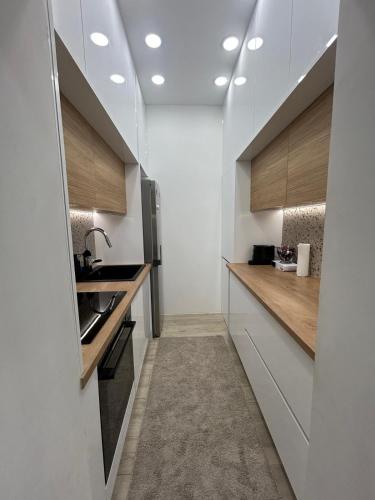 a kitchen with white walls and wooden counter tops at Lelo Sunset Spa, Romantic Garden Apartment with Private Jacuzzi in Zadar
