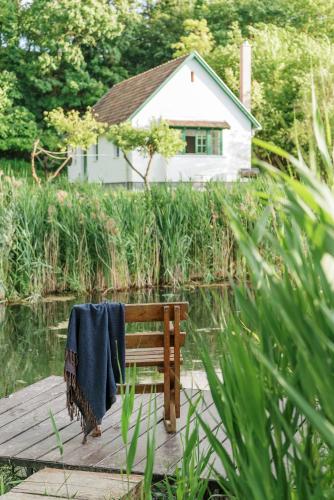 a wooden bench with a blue blanket on it sitting on a dock at Kökényház vendégház in Kötcse