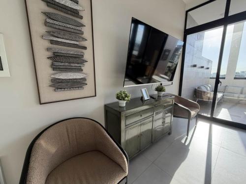a living room with a chair and a dresser and a mirror at 1B in Naco Jacuzzi very Centric in Santo Domingo