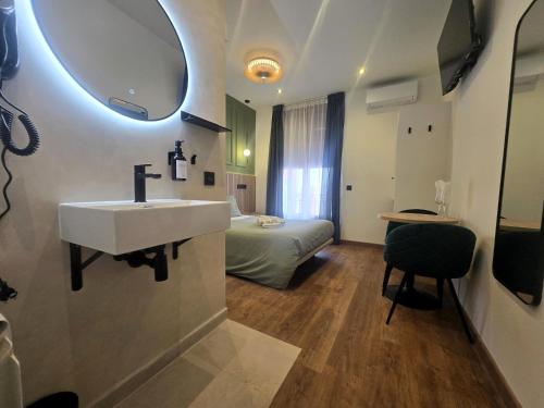 a bathroom with a sink and a bedroom with a bed at Hostal Main Street Madrid in Madrid