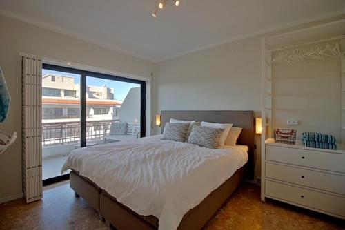 a bedroom with a large bed and a balcony at Francisco Vau Apartment in Portimão