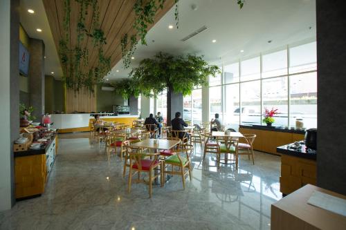 a restaurant with tables and chairs and people sitting at them at Ascent Hotel & Cafe Malang in Malang