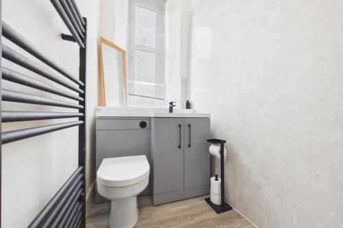 a bathroom with a toilet and a sink at West End Traditional Flat with Free Parking in Scotstoun West Station