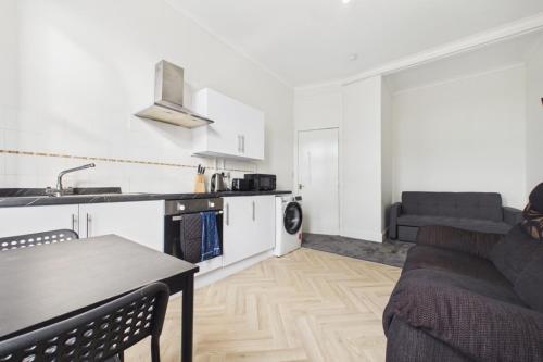 a kitchen and living room with a couch and a table at West End Traditional Flat with Free Parking in Scotstoun West Station