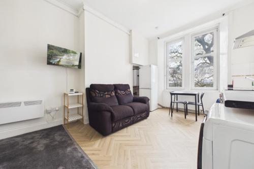 a living room with a couch and a table at West End Traditional Flat with Free Parking in Scotstoun West Station