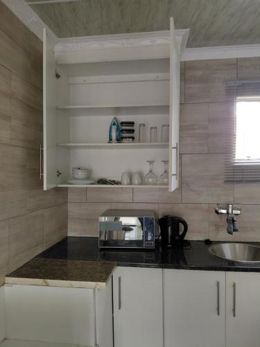 a kitchen with a counter top with a microwave at Mama R's Budget-friendly BACKROOM 3 in Newcastle