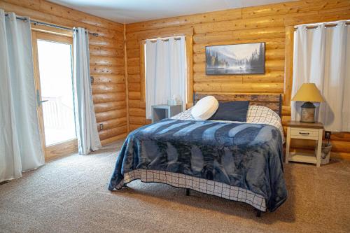 a bedroom with a bed in a room with wooden walls at Forest Glade in Sturgis