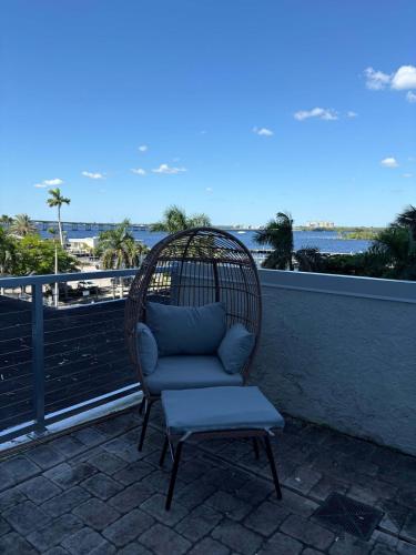 a wicker chair sitting on a balcony with a seat at Aqua Breeze Paradise in Fort Myers