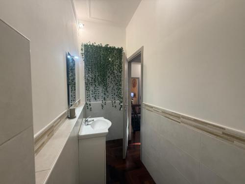 a white bathroom with a sink and a mirror at Garden suite / del ducato in Parma