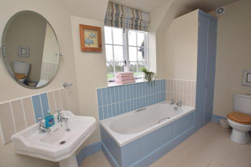 a bathroom with a tub and a sink and a mirror at 2 Bed in Biddenden oc-cb616 in Biddenden