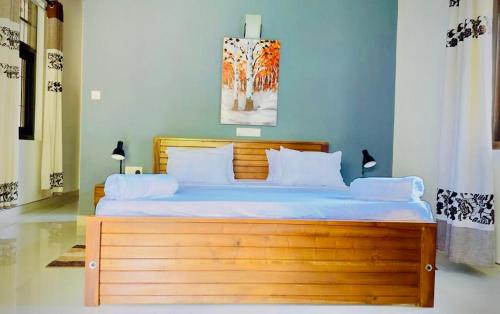 a bedroom with a large wooden bed with white pillows at Villa 188 Yala in Tissamaharama