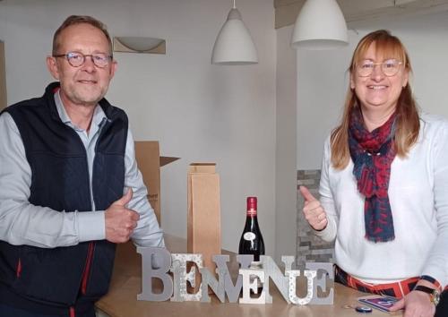 a man and woman giving thumbs up next to a bottle of wine at LES DIVINES BOURGOGNE in La Rochepot