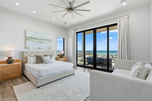 a white bedroom with a bed and a couch at Honeysuckle Blue in Pensacola Beach