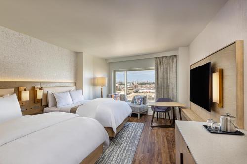 a hotel room with two beds and a television at The Westin Jersey City Newport in Jersey City