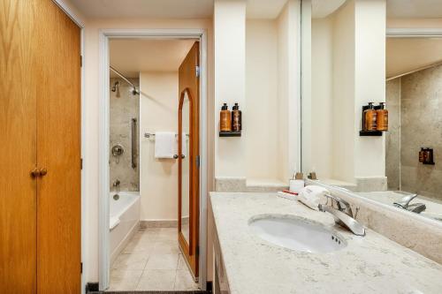 a bathroom with a sink and a tub at Fiesta Inn Express Puebla Finsa in Puebla