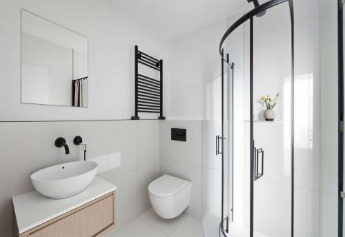 a bathroom with a sink and a toilet and a shower at The Wimbledon Collection 2 Bed Apartments in London
