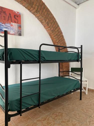 two bunk beds in a room with a brick wall at Home Ringo in Belvedere Marittimo