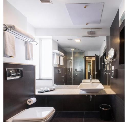 a bathroom with a toilet and a sink and a shower at Purple Brigade, Bangalore in Bangalore