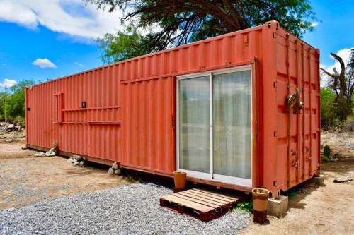 an orange shipping container with a bench in front of it at Abc in Primavera do Leste