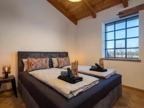 two beds in a room with a large window at Scheune 1746 in Tating