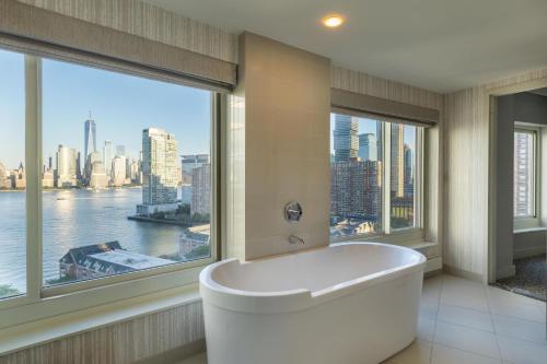 a bathroom with a tub and a large window at The Westin Jersey City Newport in Jersey City