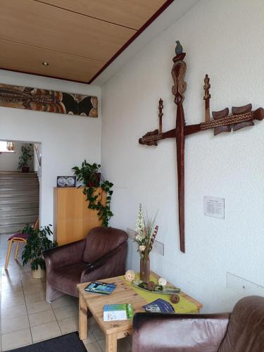 a living room with a cross hanging on the wall at Haus Lutherrose in Neuendettelsau