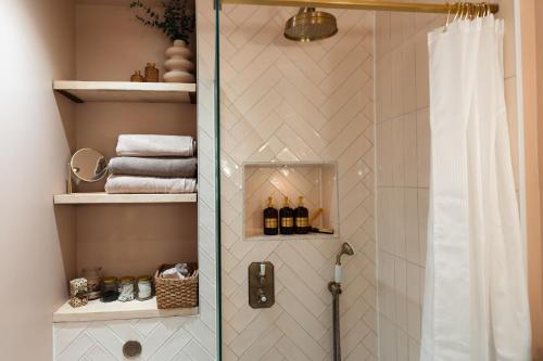 a shower with a glass door and towels in a bathroom at Period apartment in the heart of Bournemouth in Bournemouth