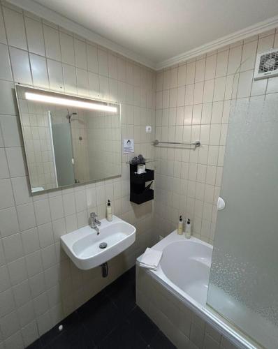a bathroom with a sink and a tub and a mirror at 2Stay - A1 in Ponta Delgada