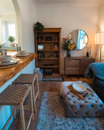 a living room with a couch and a table at Period apartment in the heart of Bournemouth in Bournemouth