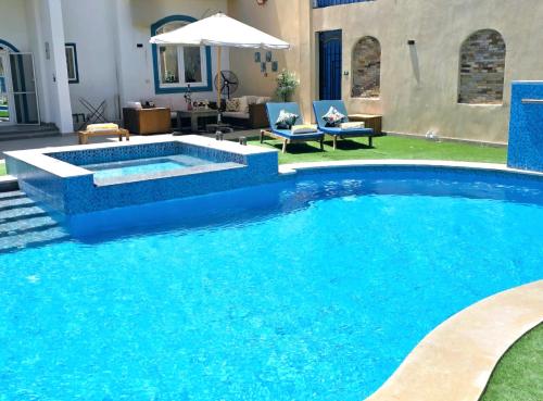 a swimming pool with blue water in a yard at Luxury Royal Blue Family Villa 8pers private pool in Hurghada