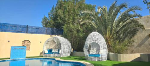 two white wicker arches around a swimming pool at Luxury Royal Blue Family Villa 8pers private pool in Hurghada