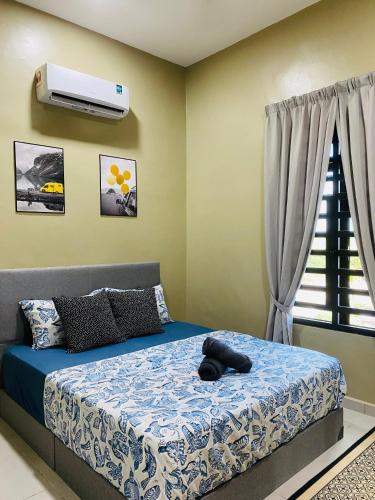 a bedroom with a bed and a air conditioner at Homestay Teratak Nailufar in Pekan