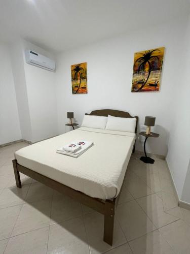 a bed in a bedroom with two pictures on the wall at Larriba Santa Maria by RPG Group in Santa Maria
