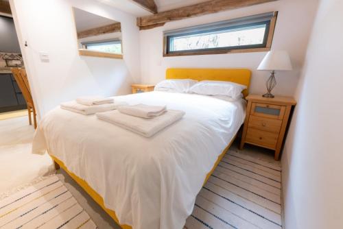 a bedroom with a white bed and a window at The Cartshed in Llanvetherine