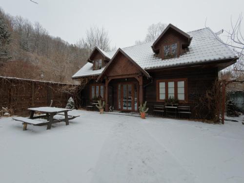 a log cabin with a picnic table in the snow at Pokoje gościnne Fermata in Kazimierz Dolny