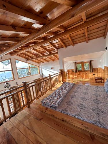 a large room with a large bed on a wooden deck at Pine Grey Castle in Almora