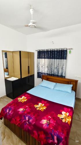 a bedroom with a bed with a red blanket at Happy Homes in Palakkad