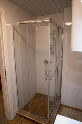 a shower with a glass enclosure in a bathroom at Harmony Studio Suite in Jagodina