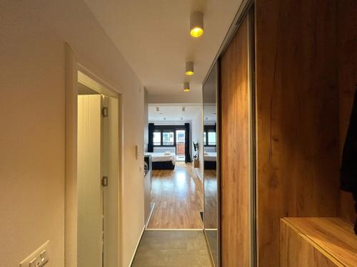a hallway with a glass door leading to a living room at Harmony Studio Suite in Jagodina