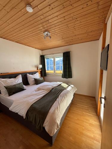 a bedroom with a large bed with a wooden ceiling at Mittagsspitz am Bauernhof in Flattach