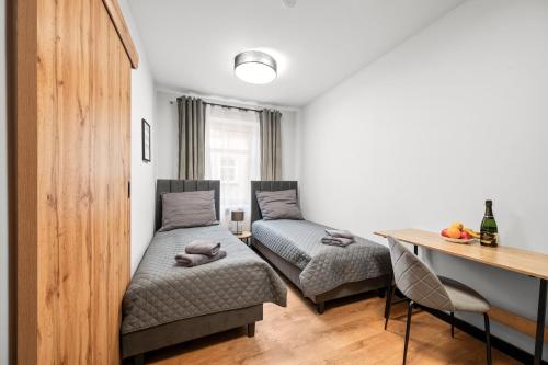 a living room with two beds and a table at Centrum Prestige Apartments in Rybnik